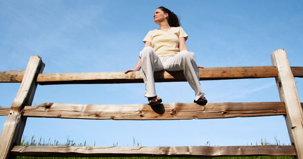 Woman sitting on a fence