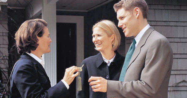 Real estate agent handing keys to her clients