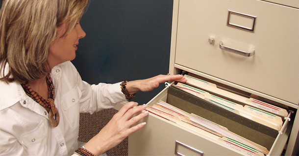 woman looking through filing cabinet